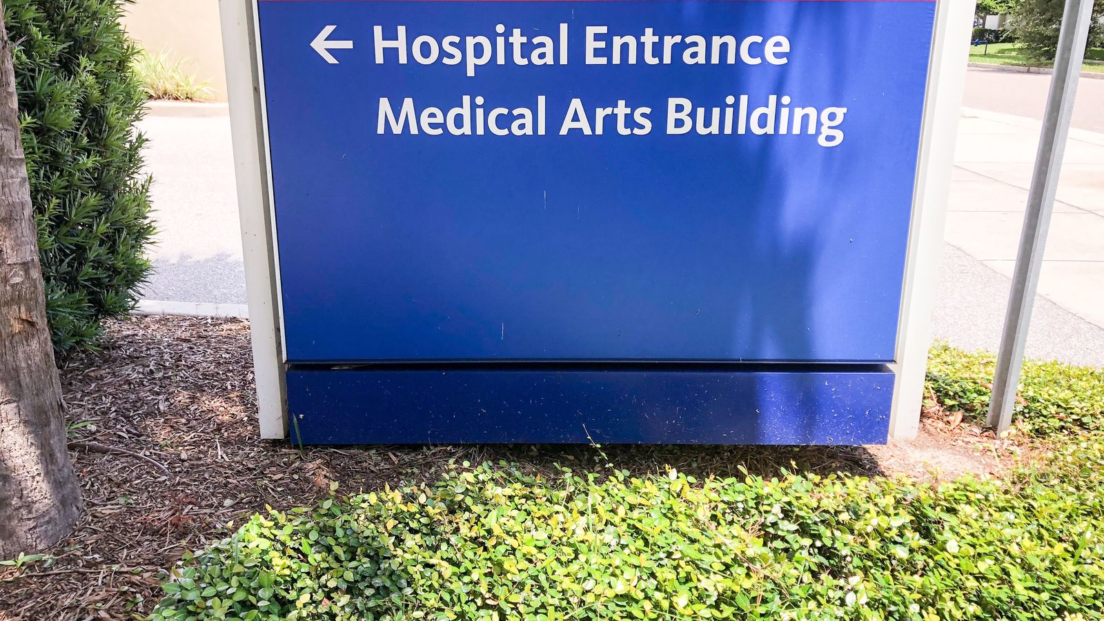 Blue sign pointing to Hospital Entrance and Medical Arts Building