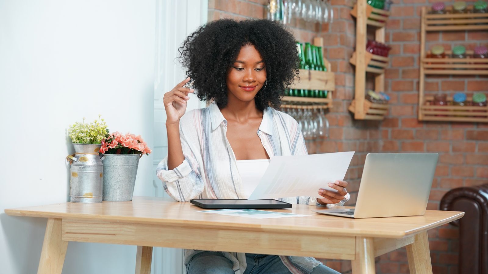 Woman works from home with laptop and documents