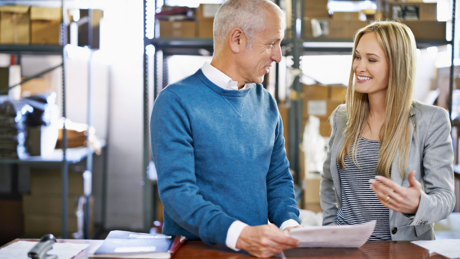 Man and woman discussing a document in a small warehouse office