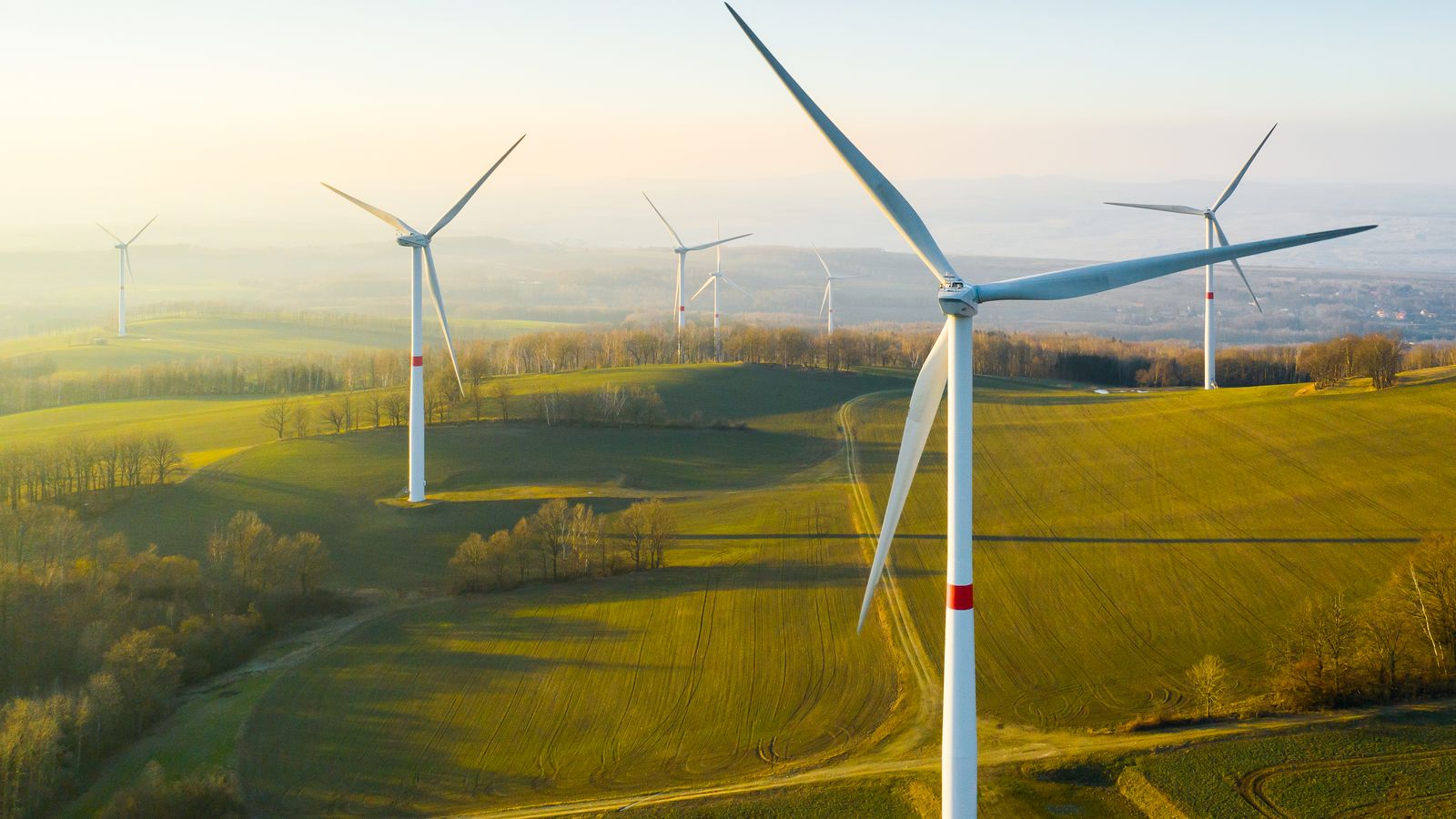 Wind turbines on rolling hills at sunrise