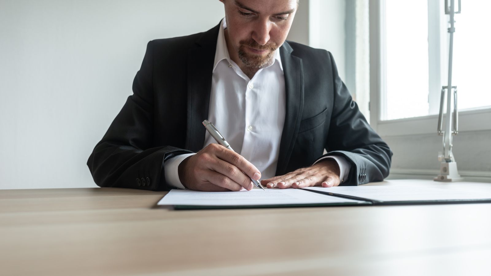Man signing documents at desk in office