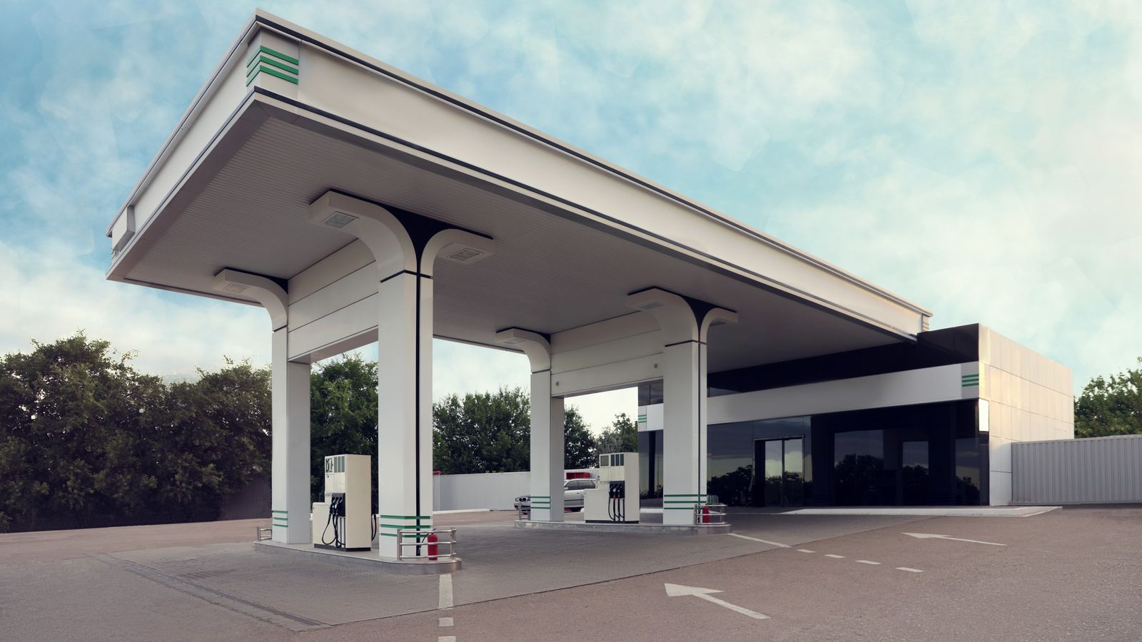 Empty modern fuel station forecourt with canopy under a clear sky