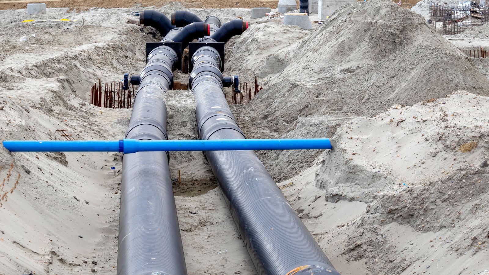Pairs of insulated pipes laid in a sandy trench