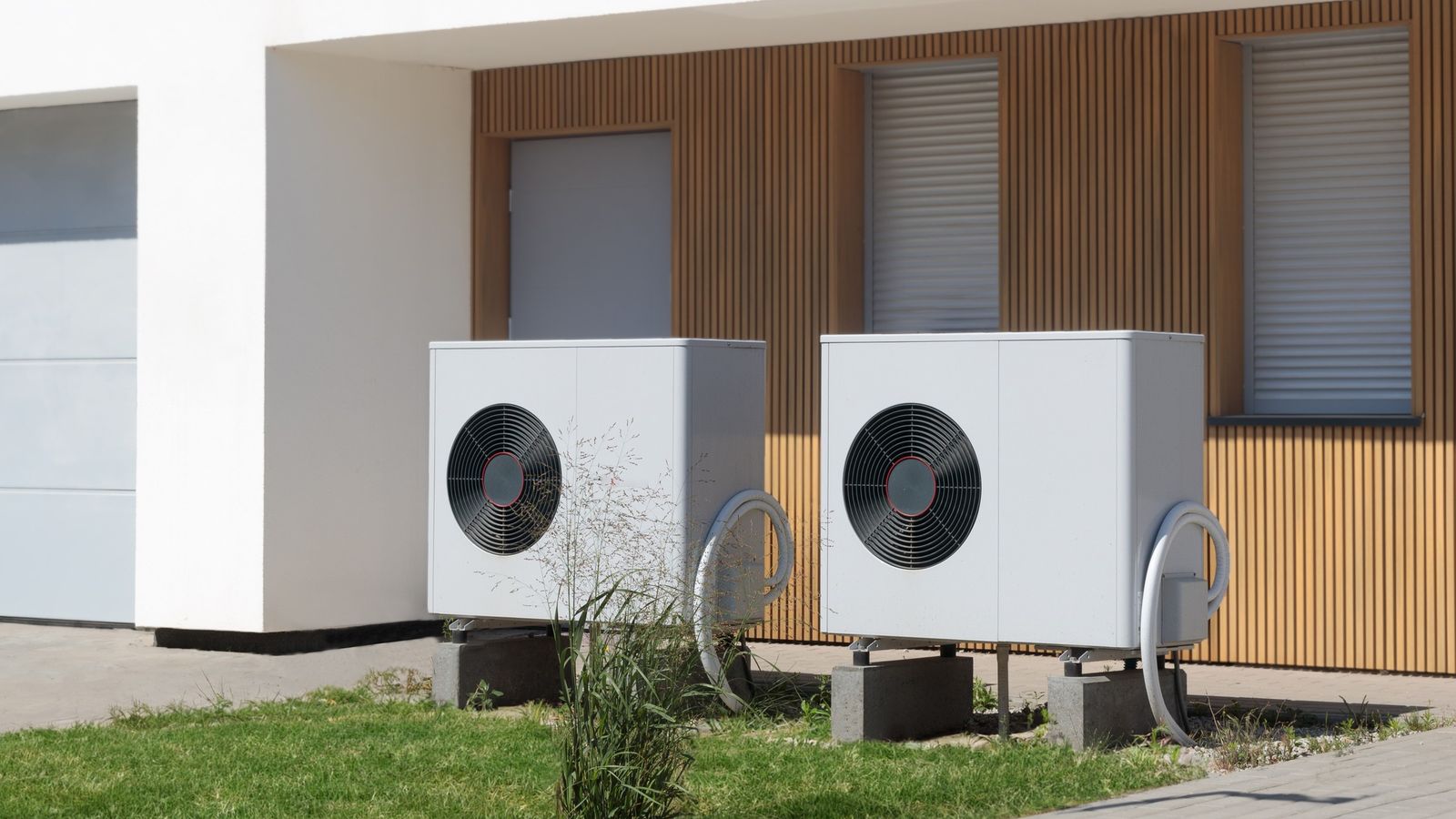 Two air-source heat pump units outside a modern building