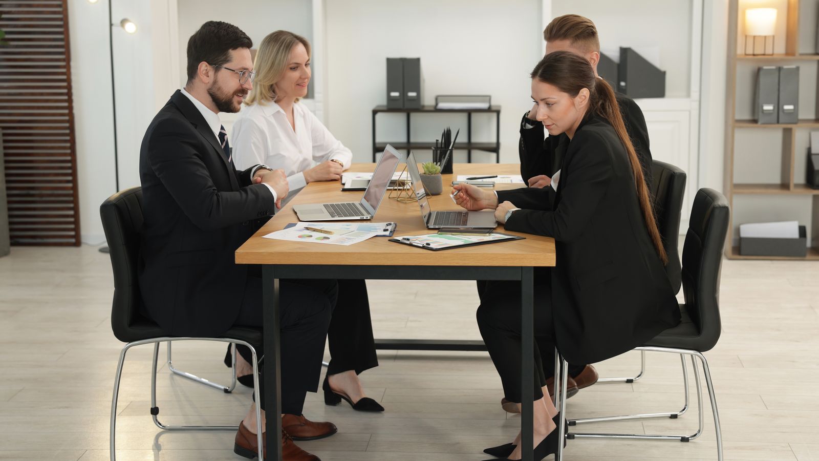 Two sides meeting across a conference table with documents